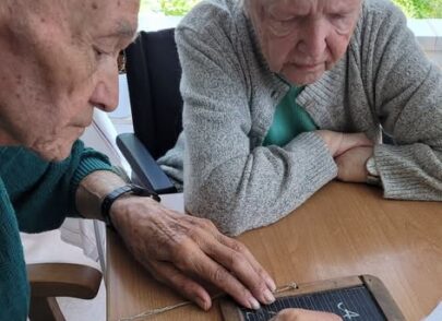 Bewohner schreibt ABCD auf eine Schiefertafel