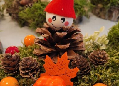 Herbstliches Gesteck mit Wichtel aus Kieferzapfen auf Baumscheibe